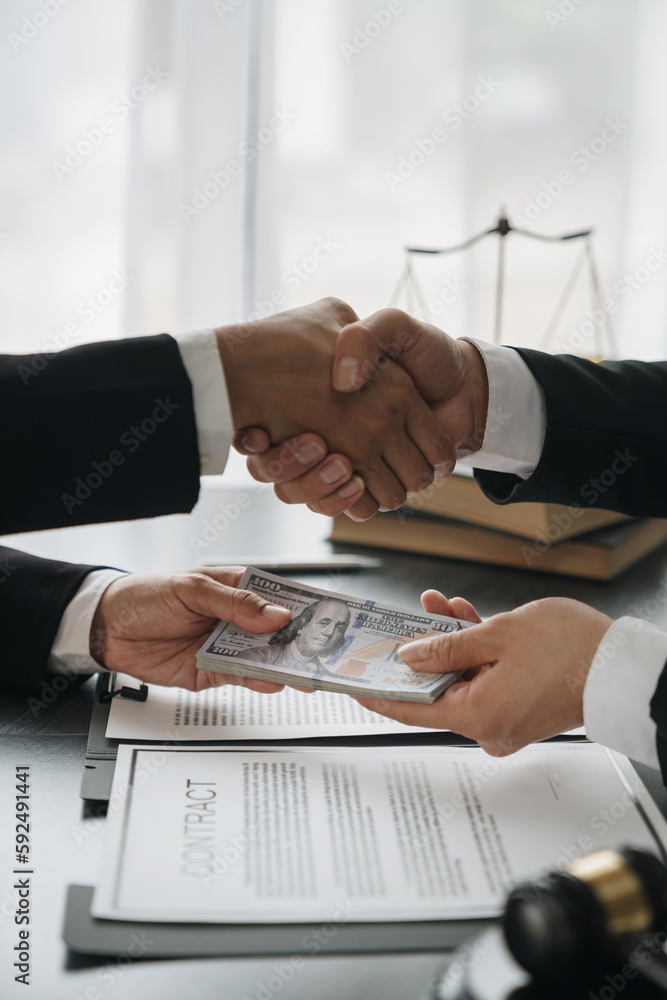 Businesswoman, investor shaking hands and giving bribe to lawyer to help win court case with documents to sign agreement The concept of bribery and money delivery on the table. Fraud Businesswoman, investor shaking hands and giving bribe to lawyer to help win court case with documents to sign agreement The concept of bribery and money delivery on the table. Fraud