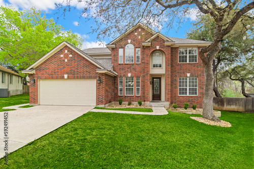 a red brick home with a green lawn