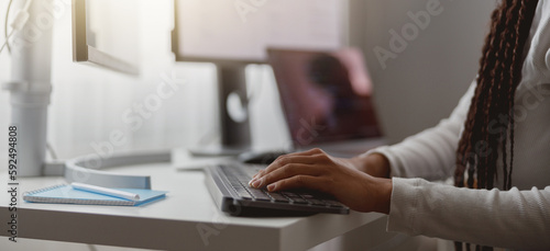 Close up shot of happy young woman working on computer, female hands typing on keyboard