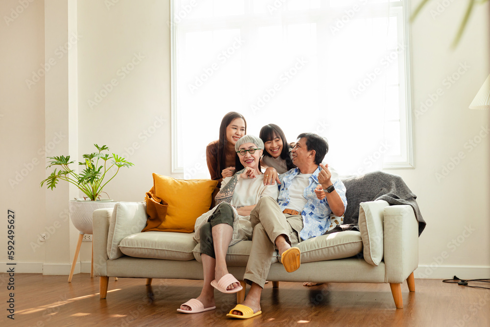 happy family Asian family, parents and children Happy sitting on the sofa in the house. The family relaxes on the sofa in the living room. happy family