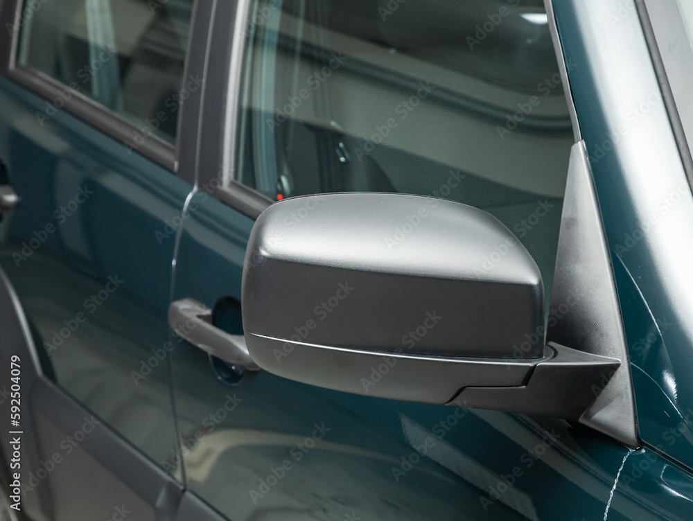 Side mirror of a green car close-up. Exterior detail Side mirror of a green car close-up. Exterior detail