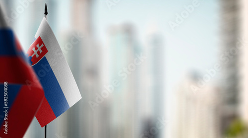 Canvas Print Small flags of the Slovakia on an abstract blurry background