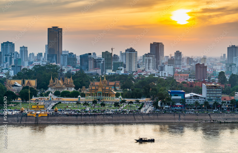 Obraz premium Phnom Penh river cruise boat passing the Royal Palace,at sunset,Cambodia.