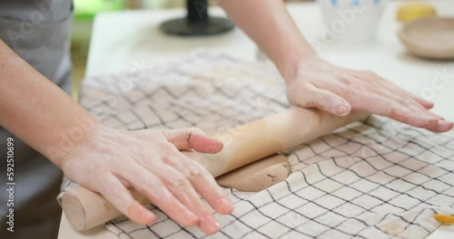 Wallpaper Mural Hobbies concept - A woman ceramist rolls clay with a rolling pin in a pottery workshop Torontodigital.ca