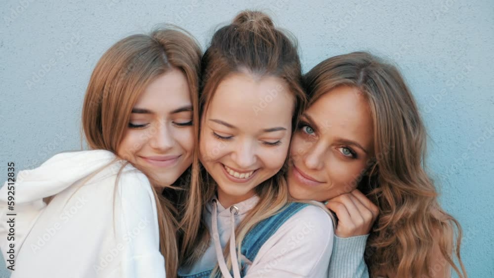 Three young female hipster friends. girls dressed in summer jeans shorts. Women smiling. Having fun and going crazy. Models posing in the street at sunset. Three young female hipster friends. girls dressed in summer jeans shorts. Women smiling. Having fun and going crazy. Models posing in the street at sunset.
