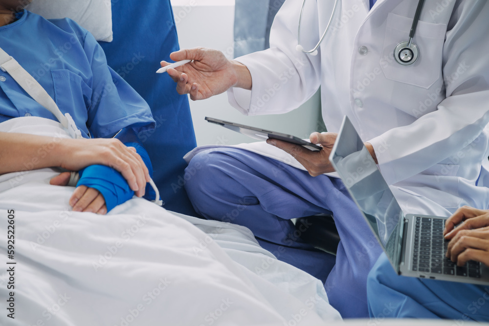 Injured patient showing doctor broken wrist and arm with bandage in hospital office or emergency room. Sprain, stress fracture or repetitive strain injury in hand. Nurse helping customer. First aid. Injured patient showing doctor broken wrist and arm with bandage in hospital office or emergency room. Sprain, stress fracture or repetitive strain injury in hand. Nurse helping customer. First aid.