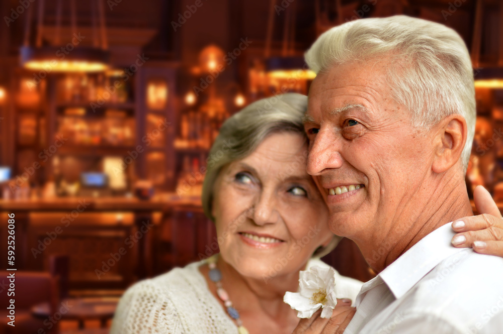 Happy old couple posing on blurred casino hall background
