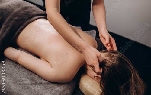 Young woman having facial massage in beauty salon