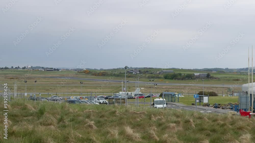 Shot of a small passenger airplane flying then landing on a runway on a wet and windy day. Shot at Stornoway Airport on the Isle of Lewis, part of the Outer Hebrides of Scotland. Shot of a small passenger airplane flying then landing on a runway on a wet and windy day. Shot at Stornoway Airport on the Isle of Lewis, part of the Outer Hebrides of Scotland.