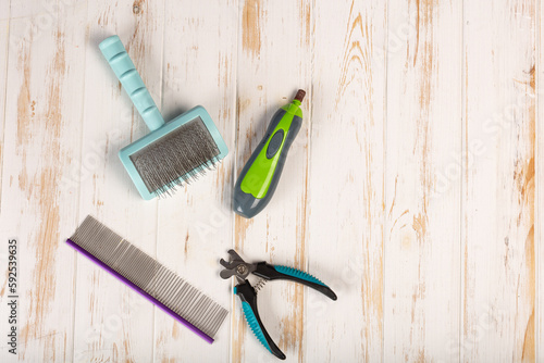 Set of tools for grooming: electric pet clipper, grooming scissors, wool brush and grooming scissors. Background with copy space on topic of pet care, Grooming, hygienic of cats and dogs.