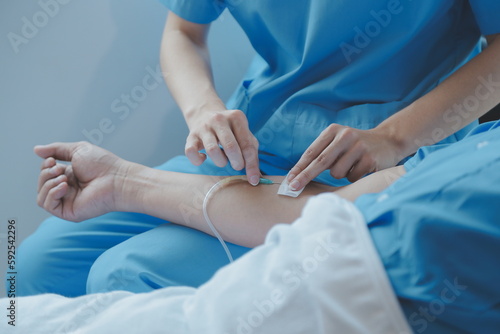 Injured patient showing doctor broken wrist and arm with bandage in hospital office or emergency room. Sprain, stress fracture or repetitive strain injury in hand. Nurse helping customer. First aid.