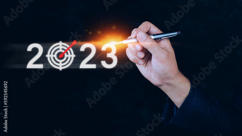 Fototapeta Naklejka Na Ścianę i Meble -  Business target and goal 2023 icon, hand pointing holding 2023 virtual screen, Start new year 2023 with a goal plan, action plan, strategy, new year business vision.