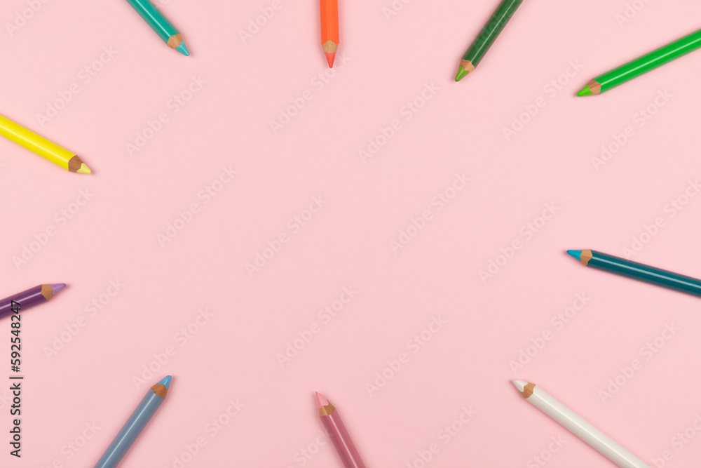Colored pencils on the pink background. Top view. Colored pencils on the pink background. Top view.