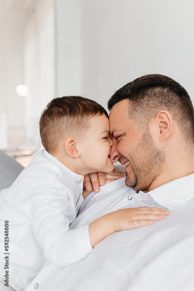 Dad plays with his little son on the sofa. Family pastime. Happy smiling people. Dad plays with his little son on the sofa. Family pastime. Happy smiling people.