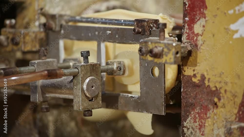 Closeup of a soap stamping or soap shaping machine at the production line Closeup of a soap stamping or soap shaping machine at the production line
