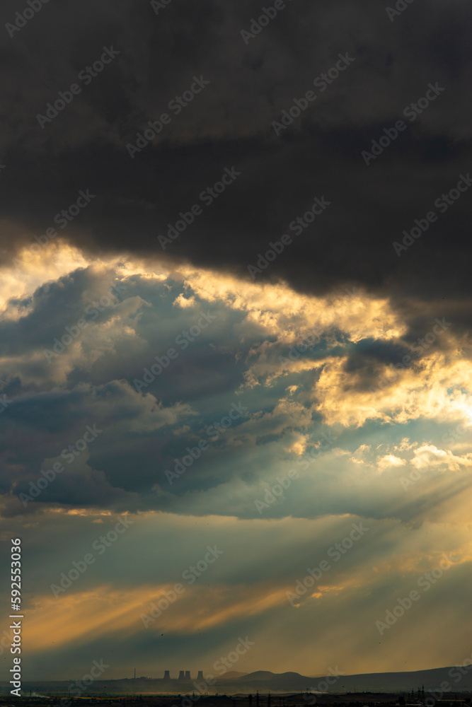 Fototapeta premium Pipes of a nuclear power plant on the background of a dramatic sky