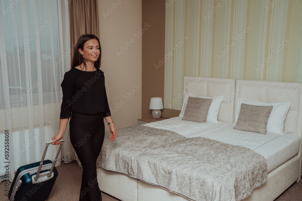A business woman in a black modern combination leaves the hotel room while carrying a suitcase with her A business woman in a black modern combination leaves the hotel room while carrying a suitcase with her