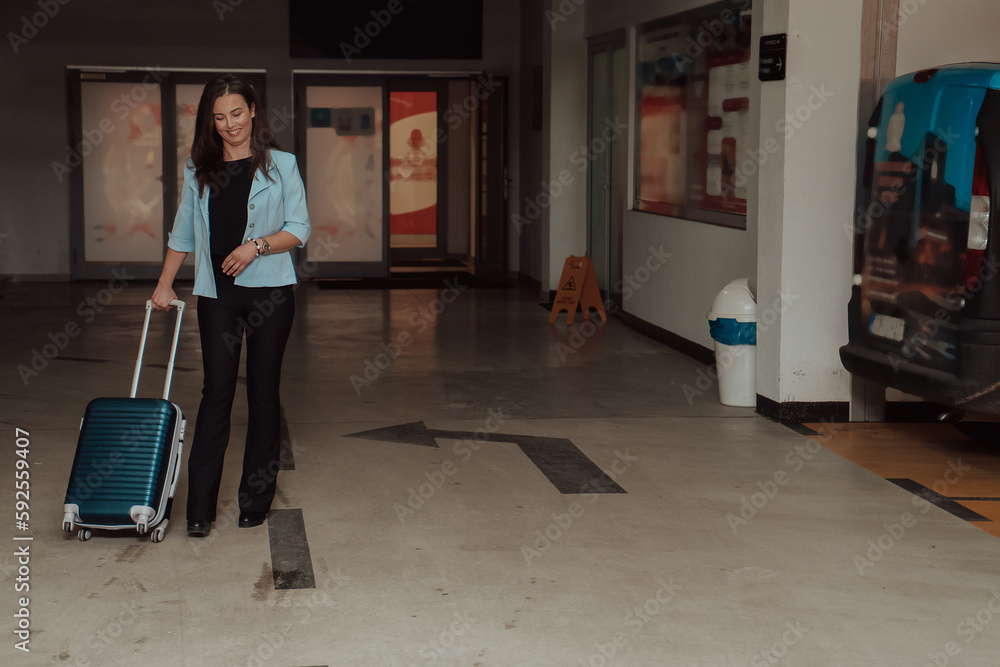 Fototapeta premium A business woman with a suitcase set in a modern garage while going to the airport. Business travel concept