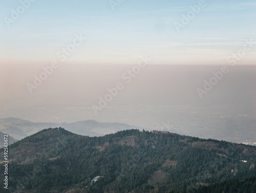 A tranquil morning in Germanys Black Forest, the horizon cloaked by fog and mist. Idyllic nature with mountains, ridges and trees creating a peaceful landscape