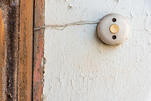 Foto An old bell button on a white crumbling facade