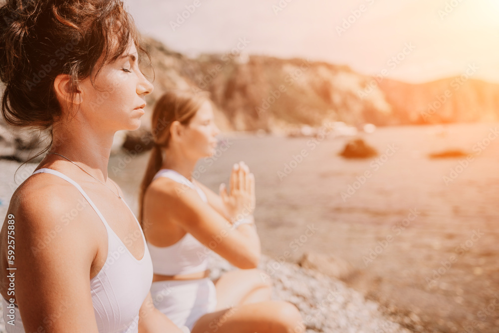 Woman sea yoga. Happy women meditating in yoga pose on the beach, ocean and rock mountains. Motivation and inspirational fit and exercising. Healthy lifestyle outdoors in nature, fitness concept.