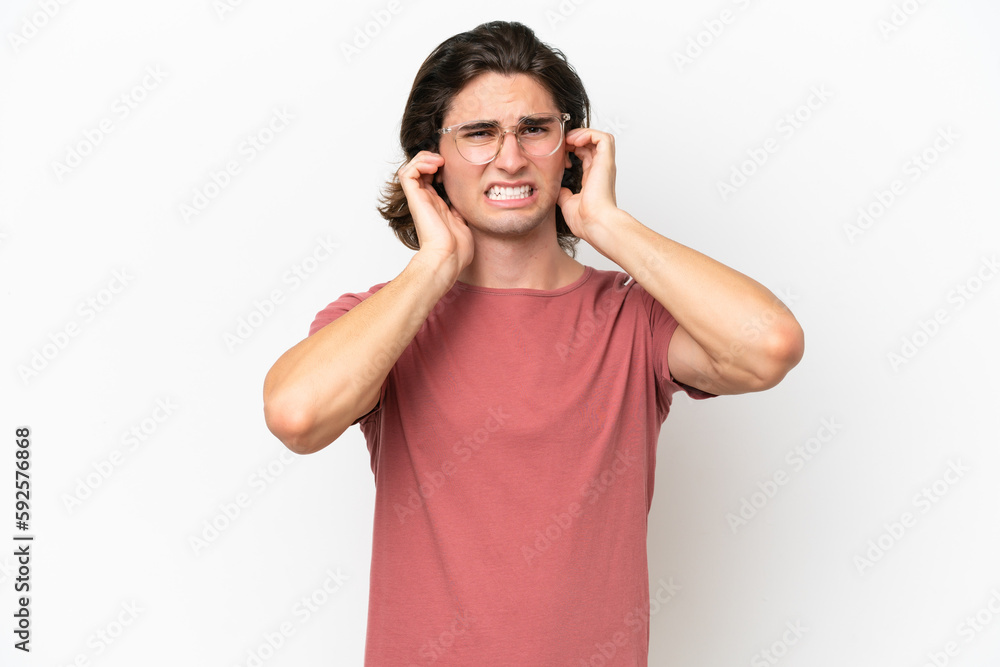 Young handsome man isolated on white background frustrated and covering ears Young handsome man isolated on white background frustrated and covering ears