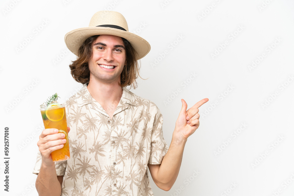 Young handsome man holding a cocktail isolated on white background pointing finger to the side Young handsome man holding a cocktail isolated on white background pointing finger to the side