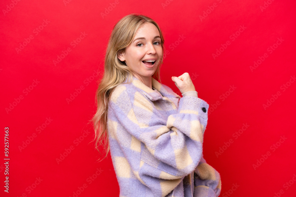 Young English woman isolated on red background celebrating a victory Young English woman isolated on red background celebrating a victory