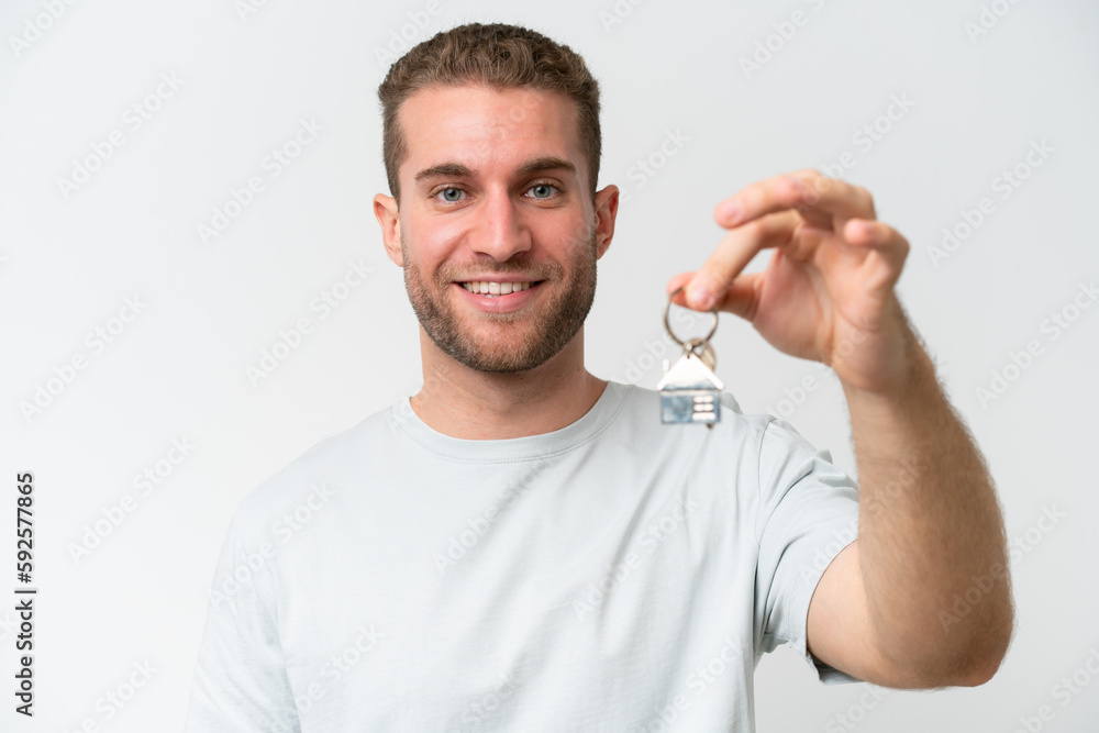 Young caucasian man holding home keys isolated on white background with happy expression Young caucasian man holding home keys isolated on white background with happy expression