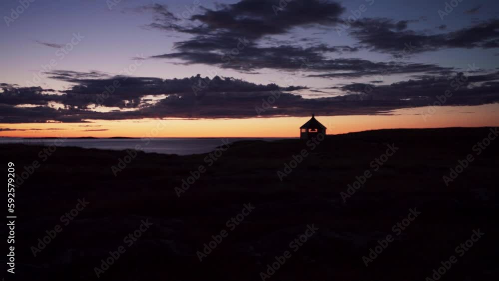 Silhouetted Hut Against Sky And Dark Clouds During Sunset. - handheld Silhouetted Hut Against Sky And Dark Clouds During Sunset. - handheld
