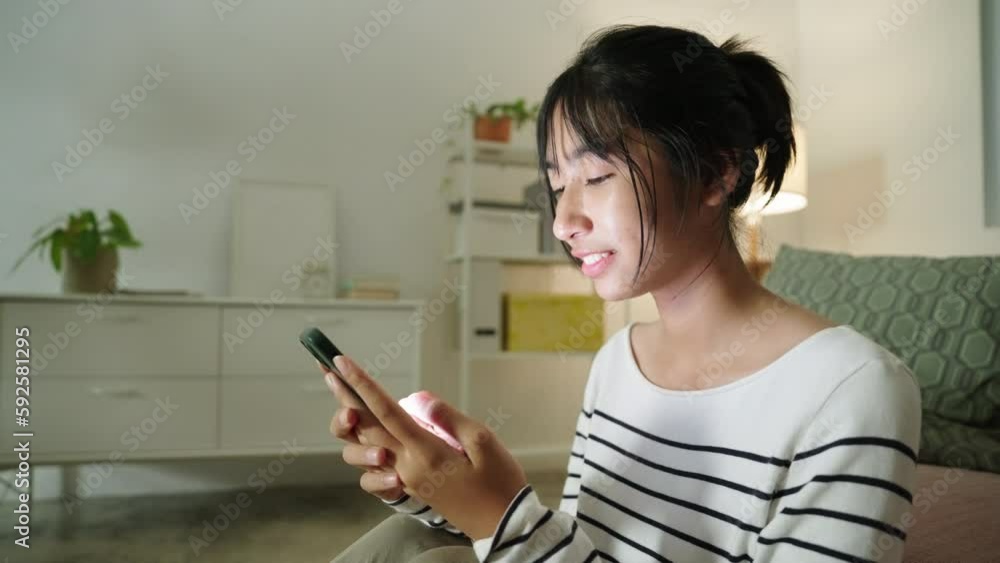 Young Asian woman using mobile phone play social media. Asian woman typing chat on mobile phone enjoy indoors at night. Young Asian woman using mobile phone play social media. Asian woman typing chat on mobile phone enjoy indoors at night.
