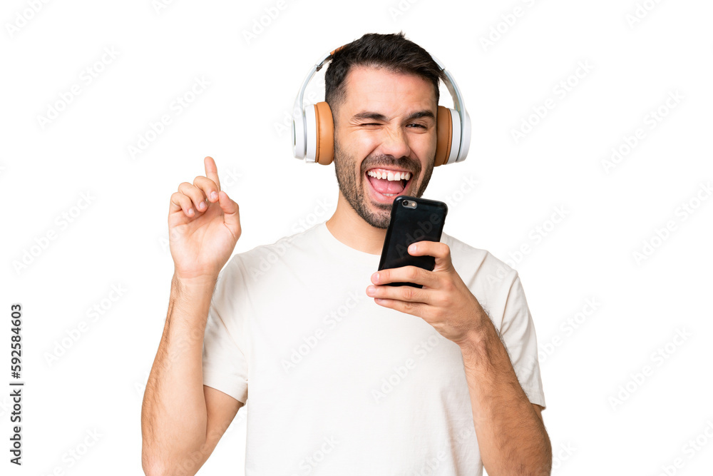 Young caucasian man over isolated chroma key background listening music with a mobile and singing Young caucasian man over isolated chroma key background listening music with a mobile and singing