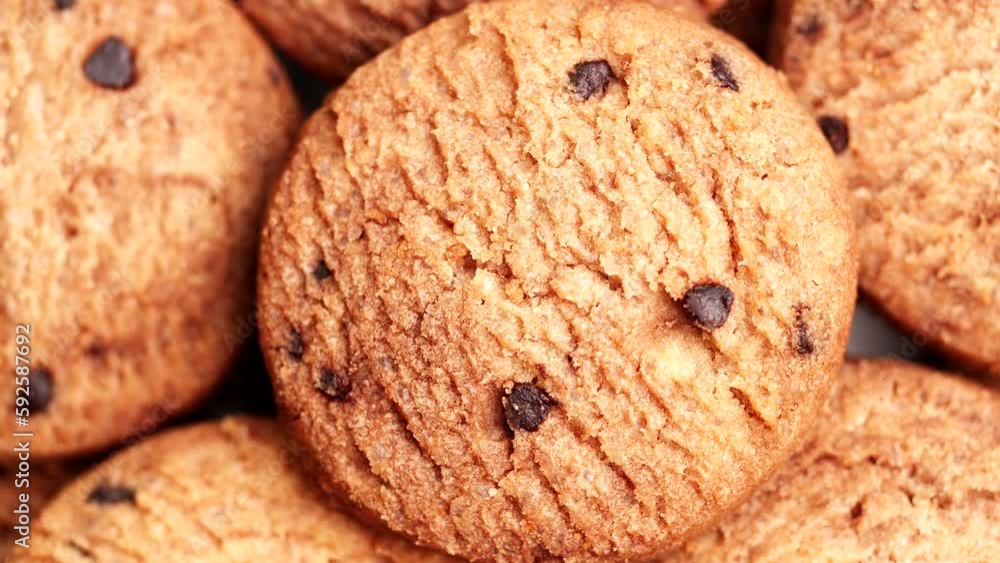 Chocolate chip cookies turning, rotating on table, slow motion. Extreme close-up Homemade Cookies top view. Concept of Dessert, Snack, Biscuit, Chocolate Cookies, Bakery, Food, Unhealthy Food
