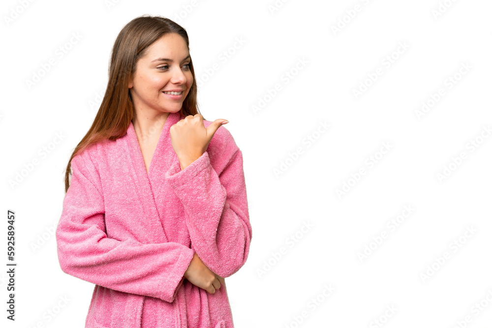Young woman in a bathrobe over isolated chroma key background pointing to the side to present a product Young woman in a bathrobe over isolated chroma key background pointing to the side to present a product