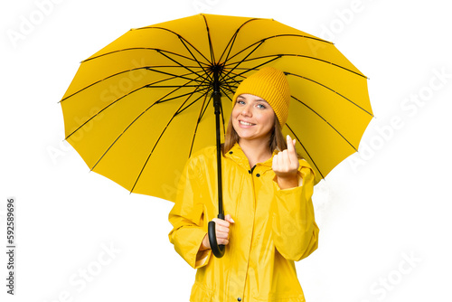 Young blonde woman with rainproof coat and umbrella over isolated chroma key background making money gesture