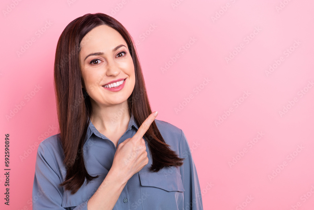 Photo of positive stunning lady wear trendy grey clothes arm direct empty space buy nice product isolated on pink color background Photo of positive stunning lady wear trendy grey clothes arm direct empty space buy nice product isolated on pink color background