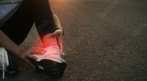 Ankle twist sprain accident in sport exercise running jogging.low key lighting. photo
