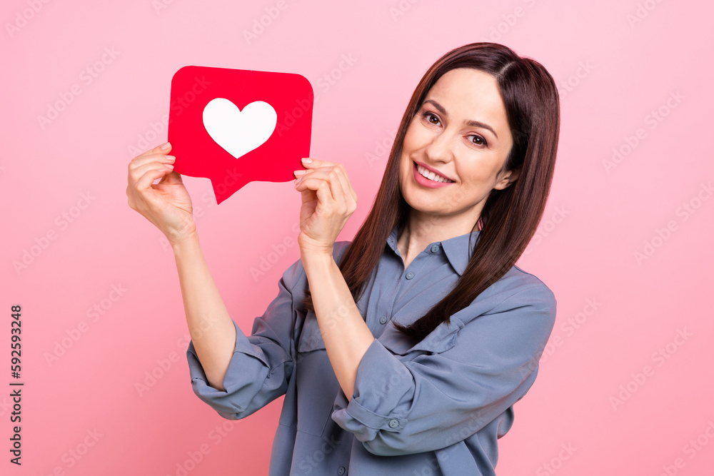 Photo of adorable gorgeous glad lady blogger wear trendy grey clothes showing red paper card isolated on pink color background Photo of adorable gorgeous glad lady blogger wear trendy grey clothes showing red paper card isolated on pink color background