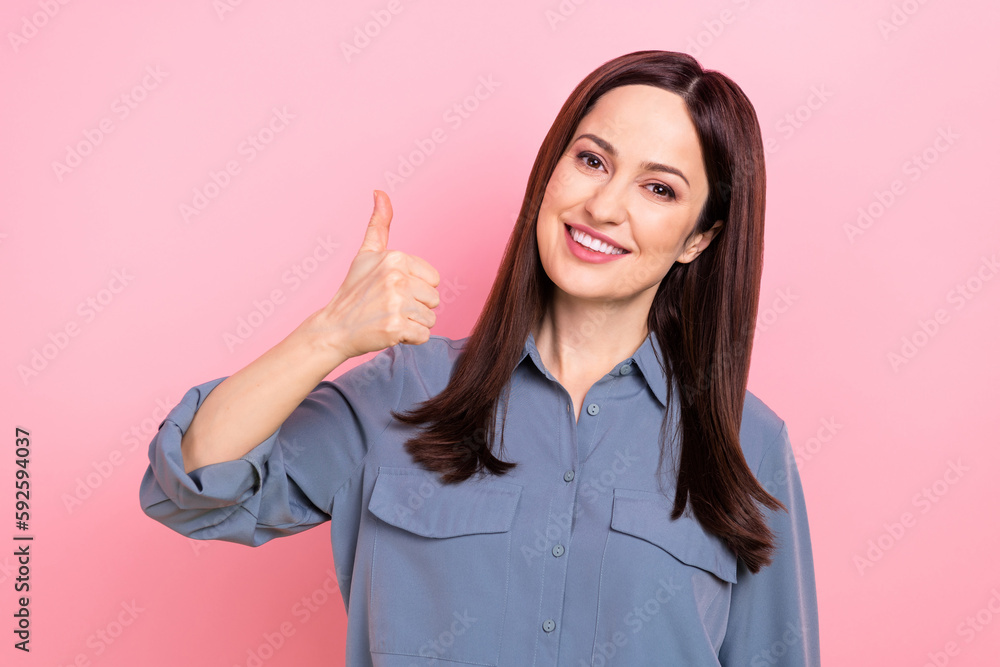 Closeup portrait of good mood smiling young professional banker businesswoman office manager thumb up her job isolated on pink color background Closeup portrait of good mood smiling young professional banker businesswoman office manager thumb up her job isolated on pink color background