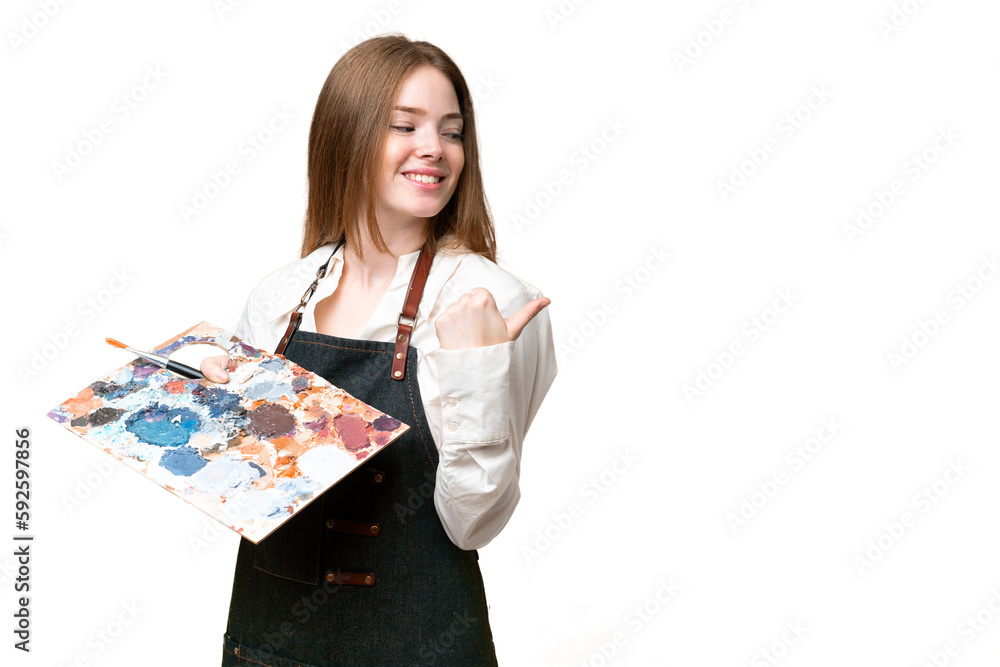 Young artist woman holding a palette over isolated chroma key background pointing to the side to present a product Young artist woman holding a palette over isolated chroma key background pointing to the side to present a product
