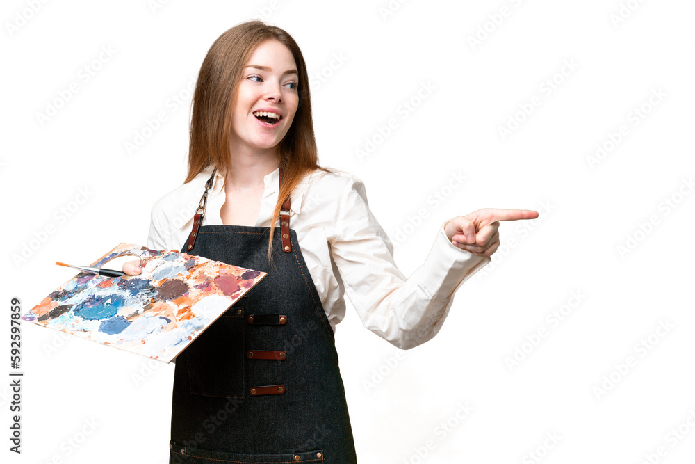 Young artist woman holding a palette over isolated chroma key background pointing finger to the side and presenting a product Young artist woman holding a palette over isolated chroma key background pointing finger to the side and presenting a product