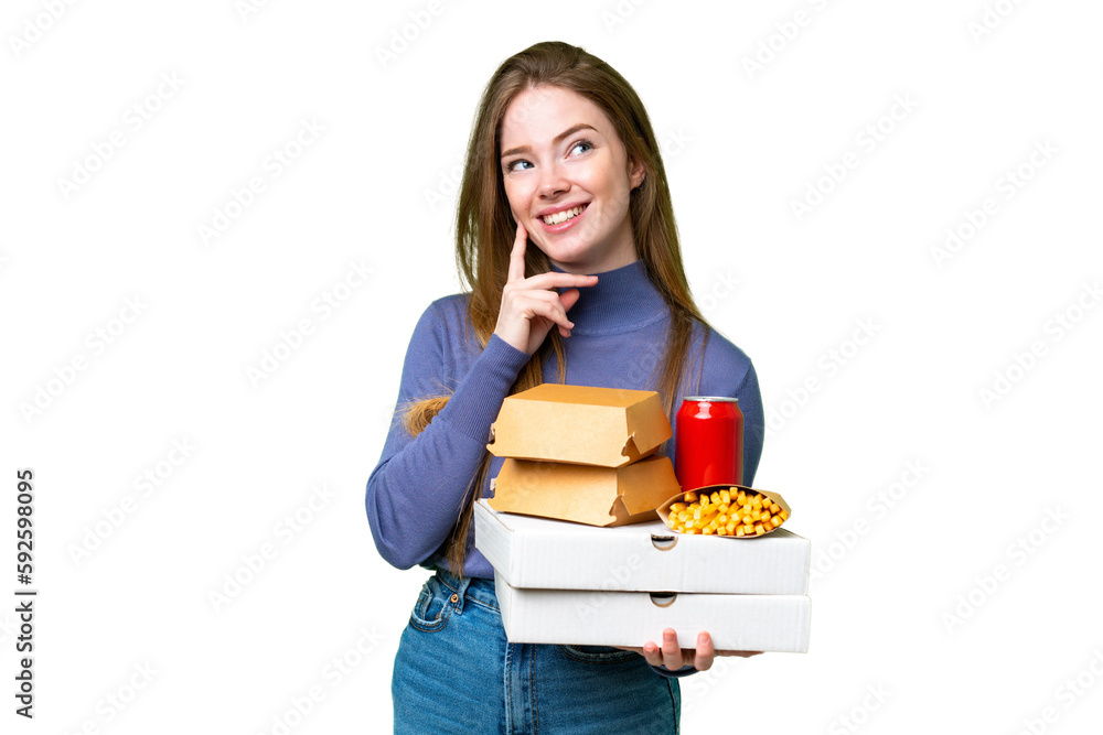 Young pretty woman holding pizzas and burgers over isolated chroma key background thinking an idea while looking up Young pretty woman holding pizzas and burgers over isolated chroma key background thinking an idea while looking up