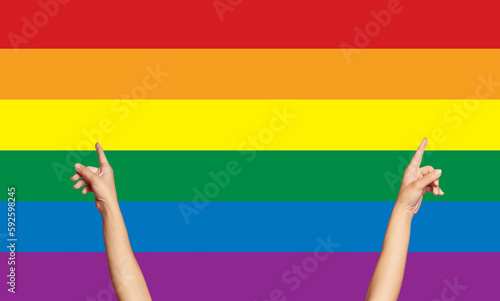Female hands up on LGBT flag background