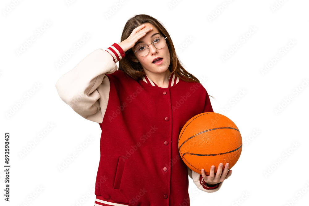 Teenager girl playing basketball over isolated chroma key background doing surprise gesture while looking to the side