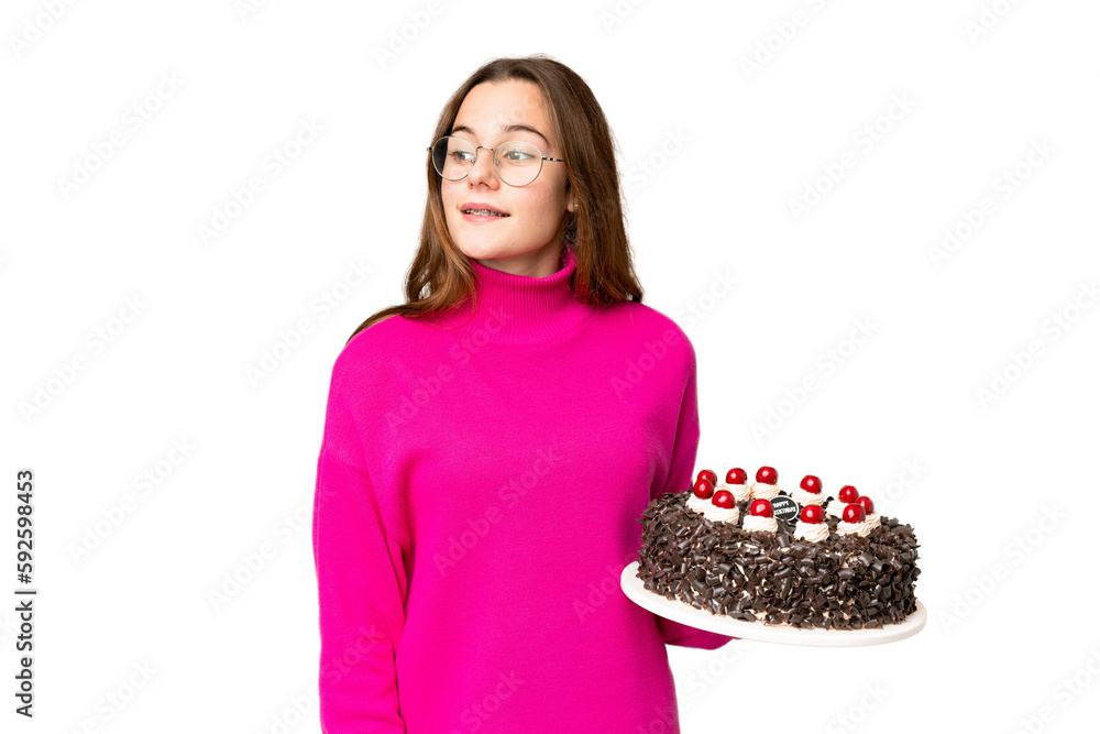 Teenager girl holding birthday cake over isolated chroma key background looking to the side and smiling Teenager girl holding birthday cake over isolated chroma key background looking to the side and smiling