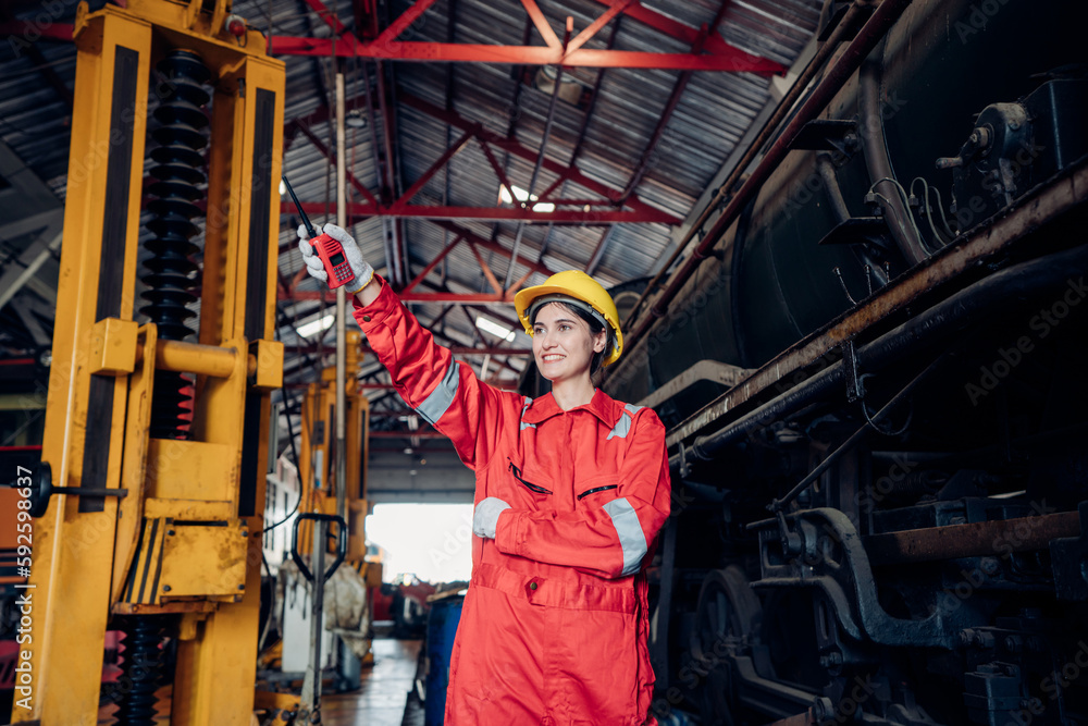 Fototapeta premium Portrait of female engineer working and looking camera in industrial factory. Women in industry concept. 