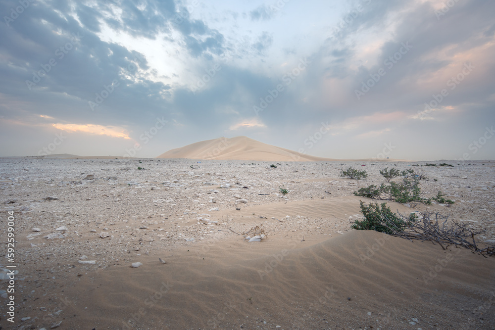 one dune at the sunset and the rocky terrain around it, in the desert one dune at the sunset and the rocky terrain around it, in the desert