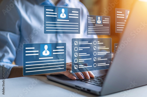 Human resources and management concept. Employees must complete the online survey form answer the test questions. Marked checklist on a clipboard. HR manager checking the employees profiles on laptop photo
