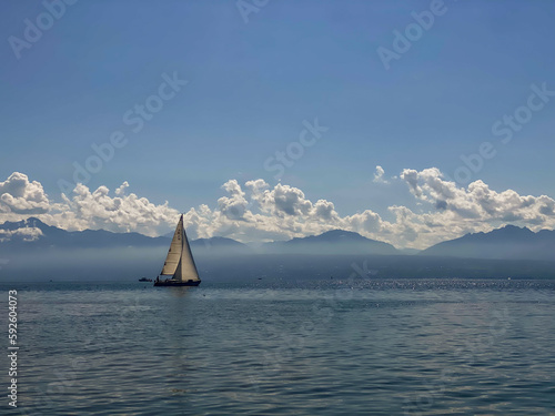 Sailing boat on the lake in front of a mountain backdrop
