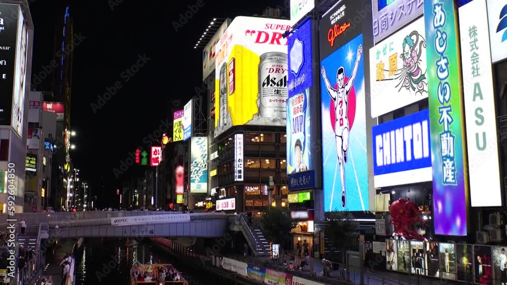 OSAKA, JAPAN : View of Dotonbori area. Tourist destinations, filled with neon signs, clubs and restaurants. Time lapse shot, sunset to night. Logo and signs are blurred or overwritten for this video.